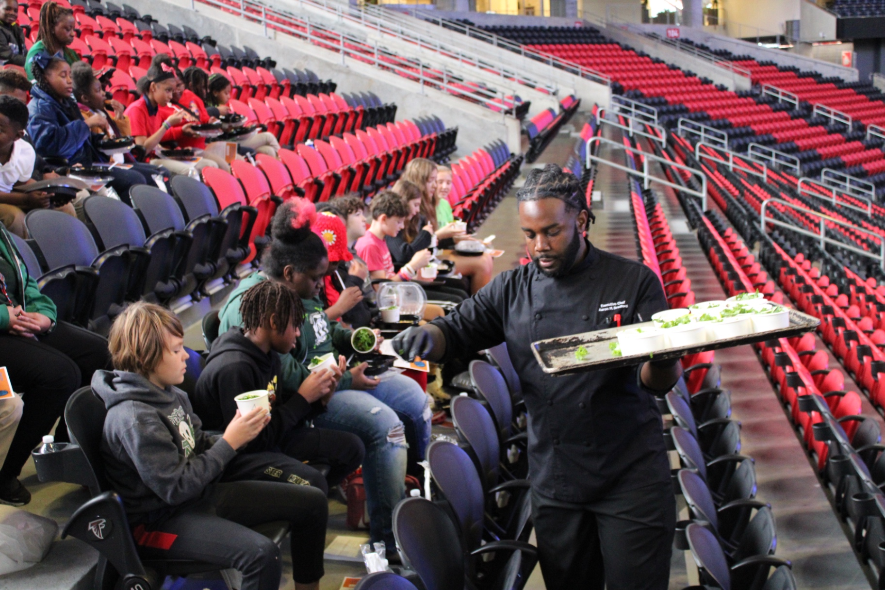 APS students tasting menu samples in the Mercedes-Benz Stadium seating area during the Chew Crew focus group